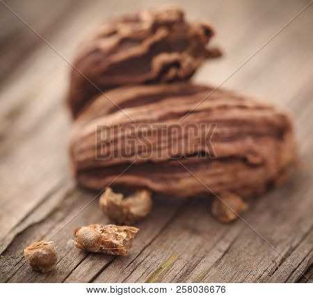 Closeup Of Black Cardamom Seeds On Timber Surface