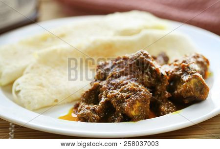 Chita Ruti A Bengali Cuisine With Hot Chicken Curry In A White Plate