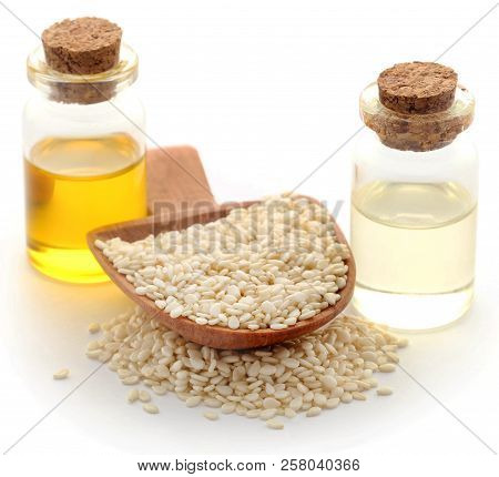 Peeled Sesame Seeds With Oil In Bottle Over White Background