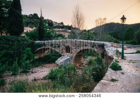 The Roman Bridge Across The Torrent De Sant Jordi At Pollenca In Mallorca At Sunset.