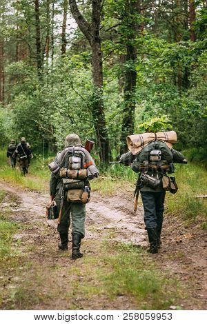 Re-enactors Dressed As German Infantry Soldier In World War Ii Marching Walking Along Forest Road In