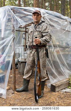 Hunter With Shotgun In The Hunting Camp Made Of Polyethylene