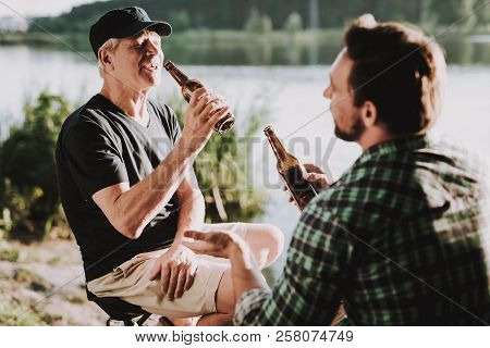 Smiling Men Drinking Beer Near River In Summer. Man In Shirt. Bearded Guy. Weekend On River. Young M