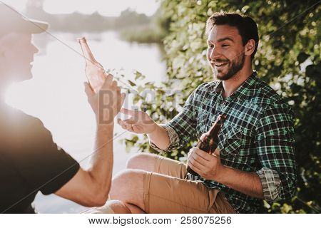 Smiling Men Drinking Beer Near River In Summer. Man In Shirt. Bearded Guy. Weekend On River. Young M