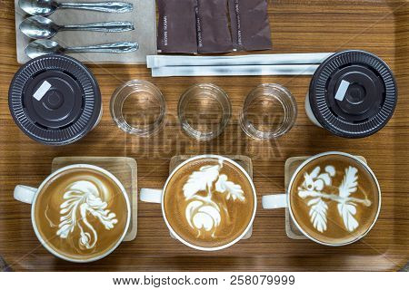 Top View Of Coffee Cup Set Which Consist Of Latte Art, Capuchino, Glassed Of Water, Spoon And Sugar 