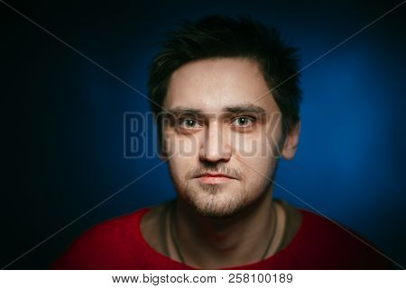Emotional Young Man Photo In Studio On Blue Background.