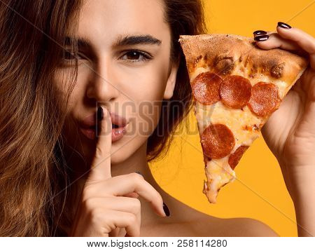 Young Beautiful Woman Hold Slice Of Pepperoni Pizza And Show Tss Quite Sing On Yellow Background