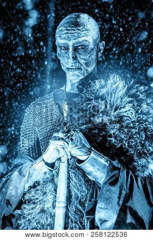 Zombie warrior in knightly armor stands in the night forest. Fantasy horror film. Halloween.