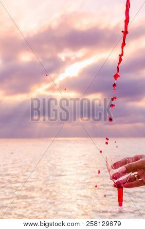 Girl Holding A Glass With Wine Uring The Sunset On The Sea