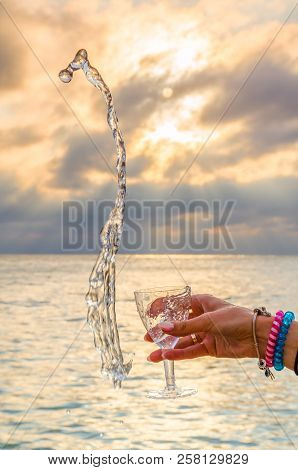 Girl Holding A Glass With Wine Uring The Sunset On The Sea