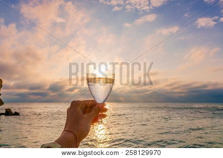 Girl Holding A Glass With Wine Uring The Sunset On The Sea