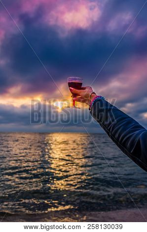 Girl Holding A Glass With Wine Uring The Sunset On The Sea