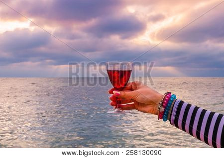 Girl Holding A Glass With Wine Uring The Sunset On The Sea