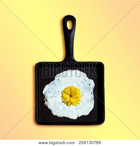 Square Cast-iron Frying Pan With Fried Eggs, Flower Of Rudbeckia Instead Of Yolk. Artificial Objects