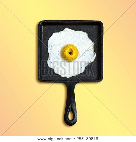 Square Cast-iron Frying Pan With Fried Eggs, Ball Of Yarn Instead Of Yolk. Artificial Objects That M