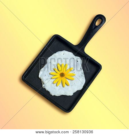 Square Cast-iron Frying Pan With Fried Eggs, Flower Of Topinambur Instead Of Yolk. Artificial Object