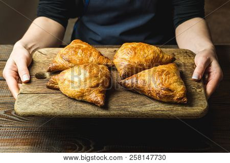 Uzbek National Dish Of Samsa On A Wooden Board In The Hands Of A Girl