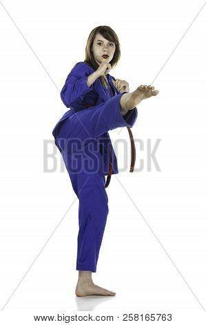 Female Red Belt Student Practicing Tae Kwon Do Martial Arts Moves In A Blue Dobok Or Gi (uniform) Is