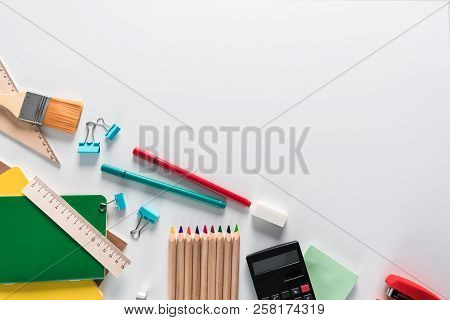 Top View Over A Notebooks, Paints, Pencils, Rulers, Paper Clips, Brushes, Stepler, Glue, Sharpener, 