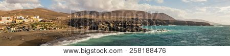AJUY, FUERTEVENTURA, - 19 FEBRUARY 2018: View of sandy beach and village of Ajuy, Fuerteventura, Canary Islands, Spain.