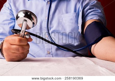 Hypertensive Patient Performing A Blood Pressure Auto Test / Man Self-monitoring Of Blood Pressure W