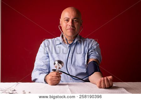 Hypertensive Patient Performing A Blood Pressure Auto Test / Man Self-monitoring Of Blood Pressure W