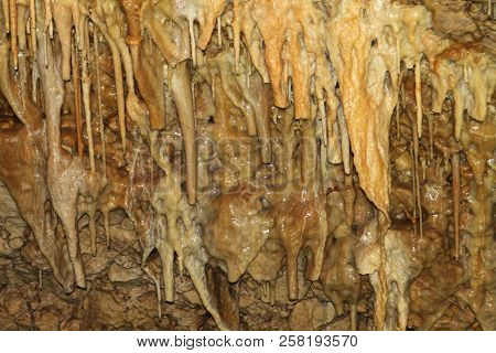 Natural Texture Image Of Fantastic Natural Cave With Gingery Walls And Formations Of Stalactites Wit