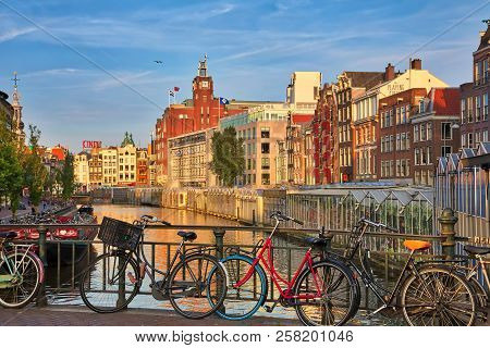 Beautiful View Of Amsterdam Canals With Bridge And Typical Dutch Houses
