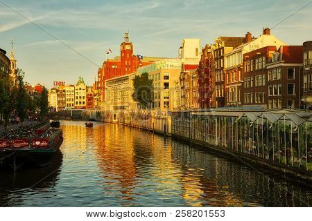Beautiful View Of Amsterdam Canals With Bridge And Typical Dutch Houses