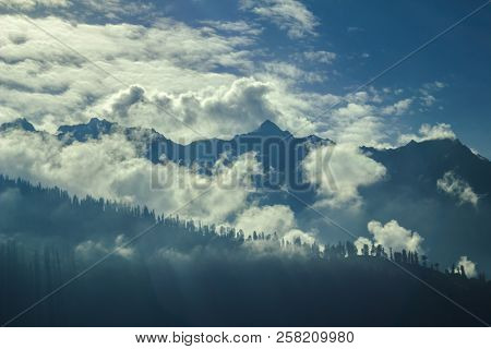 Shadow Of Trees In The Silhouetted Mountains In The Clouds