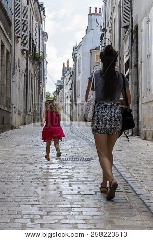 Orleans, France - August 11, 2018:  Small Alley With Trunning Child And Walking Woman And With Old H