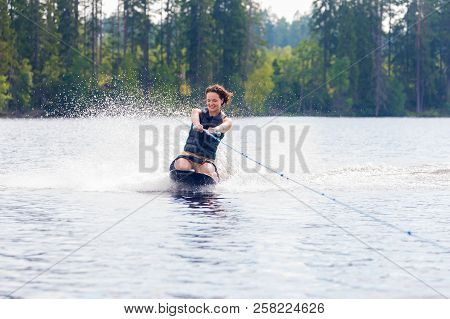 Young Athletic Woman Riding Kneeboard On A Lake