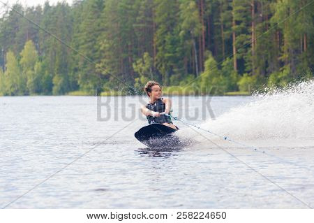 Young Athletic Woman Riding Kneeboard On A Lake
