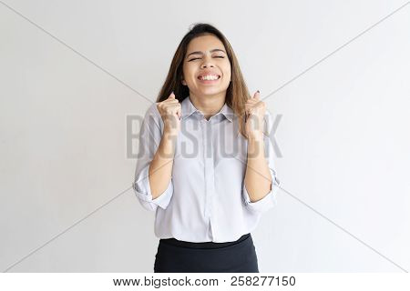 Overjoyed Girl Hoping For Good Luck. Young Mix Raced Woman Clenching Fists And Making Wish. Hope For