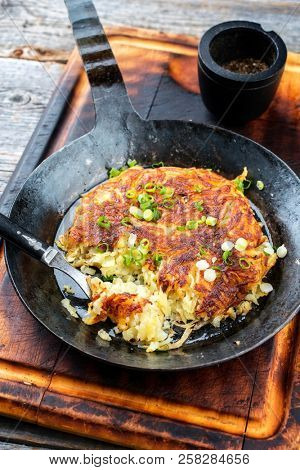 Traditional Swiss hash browns as side dish with leek as closeup in a frying pan 