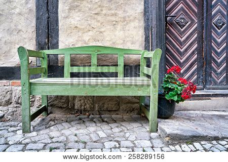 Green Bench In Front Of A Half-timbered House In The Old Town Of Quedlinburg In Germany