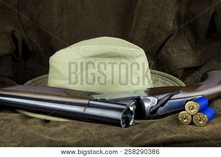 Shotgun And Hat With Cartridges On An Outdoor Coat