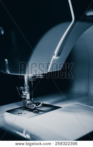 Modern Compact Electric Sewing Machine In The Evening. View Of Needle And Thread. Illumination From 
