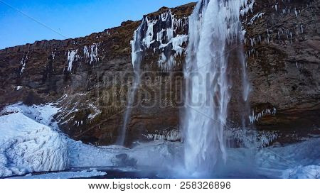 Waterfall In Freezing Cold Place Over Cliff Face