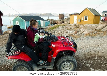 Ittoqqortoormiit, Greenland - September 9, 2012: Small Family On A Quad Bike Which Is A Popular Mode