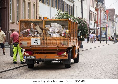 German People Sweeper Working Clean And Keep Garbage And Push Garbage Truck On The Road At Speyer To
