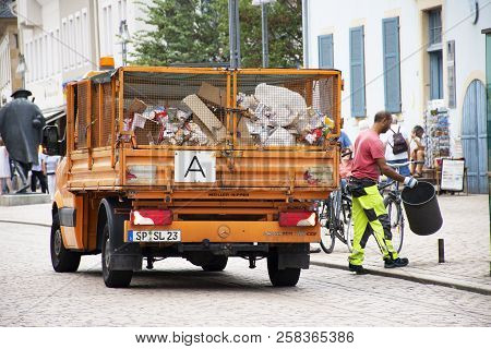 German People Sweeper Working Clean And Keep Garbage And Push Garbage Truck On The Road At Speyer To