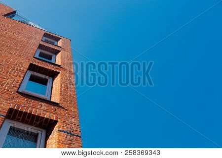 View At Side Of Red Brick Building With Modern Windows On Blue Sky Background. Bremen, Germnay