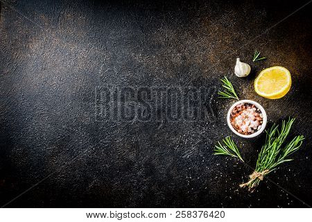 Cooking Food Ingredients Background. Spices, Garlic, Herbs, Olive Oil. Rusty Black Stone Table. Copy