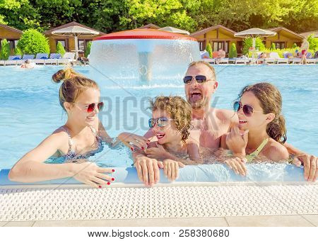 Happy Family In The Pool, Having Fun In The Water, Dad With Three Kids Enjoying Aqua Park, Beach Res