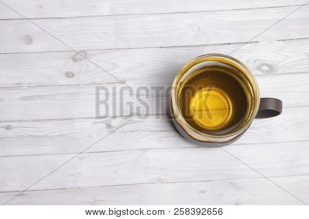 A Cup Of Green Tea With On White Wooden Table