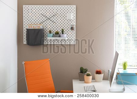 Modern Workplace And Pegboard With Different Cacti In Room