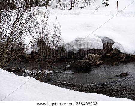 A River In A Winter Landscape With Snow