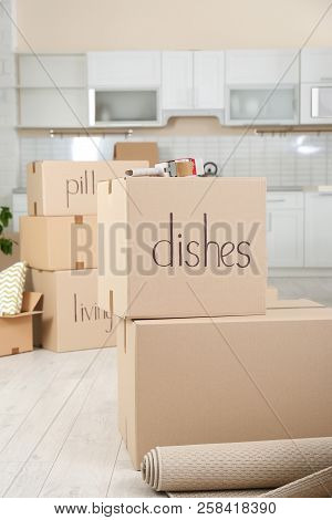 Cardboard Boxes And Adhesive Tape Dispenser In Kitchen. Moving Day