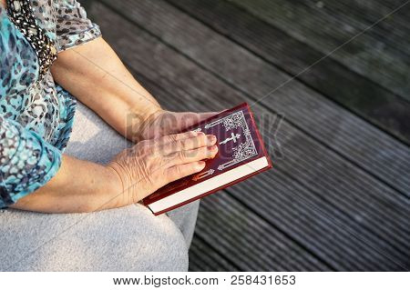 Hand Of Elderly Woman Lies On An A Bible, Woman Praying. Woman Hand With Bible Praying, Hand In Pray